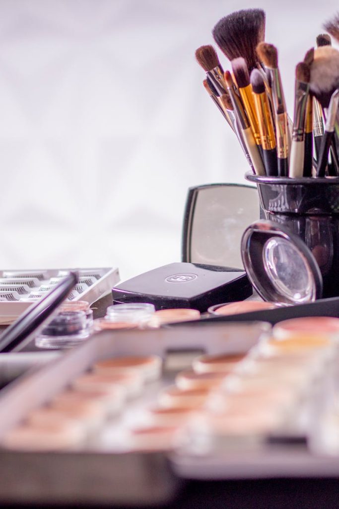 Close-up of a professional makeup brush set and cosmetics on a table for beauty use.