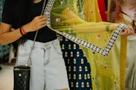 Close-up of a woman holding a vibrant ethnic sheer fabric with traditional patterns.